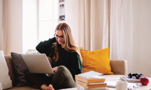 a woman on a couch with a laptop